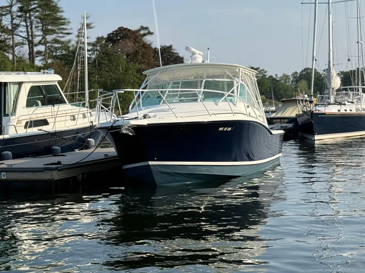Club Car Yacht Photos Pics 1999 Cabo 31 Express boat docked in a marina, surrounded by other vessels.