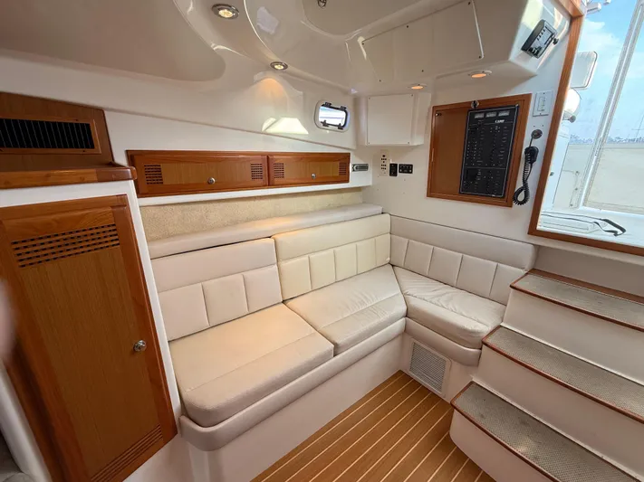 Club Car Yacht Photos Pics Interior of 1999 Cabo 31 Express boat with white seating and wooden accents.