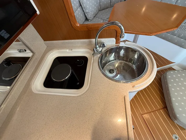 Club Car Yacht Photos Pics 1999 Cabo 31 Express boat interior with sink and stove in compact kitchen area.