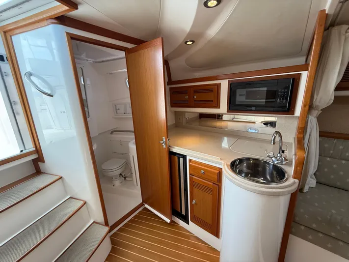 Club Car Yacht Photos Pics Interior of 1999 Cabo 31 Express boat with kitchenette and bathroom.