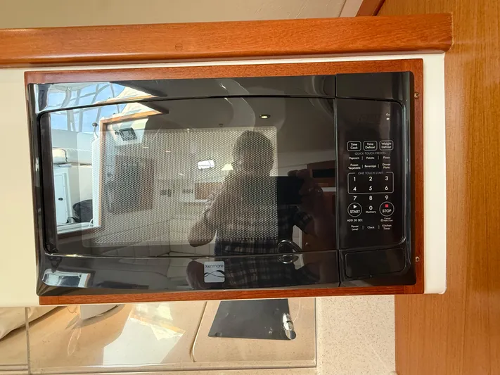 Club Car Yacht Photos Pics Microwave in 1999 Cabo 31 Express boat interior, featuring wood paneling and modern controls.