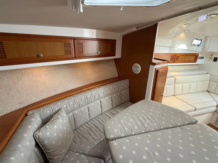 Club Car Yacht Photos Pics 1999 Cabo 31 Express cabin interior with cushioned seating and wooden cabinetry.