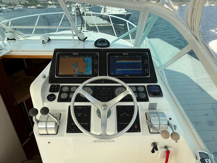 Club Car Yacht Photos Pics 1999 Cabo 31 Express helm with navigation screens and steering wheel.