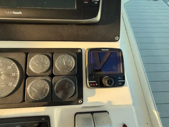 Club Car Yacht Photos Pics Control panel of a 1999 Cabo 31 Express boat with gauges and Raymarine display.