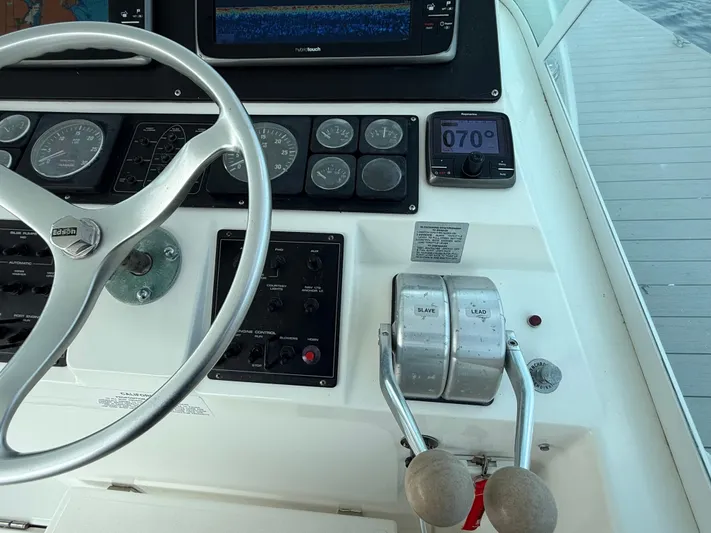 Club Car Yacht Photos Pics 1999 Cabo 31 Express helm with steering wheel, gauges, and throttle controls.