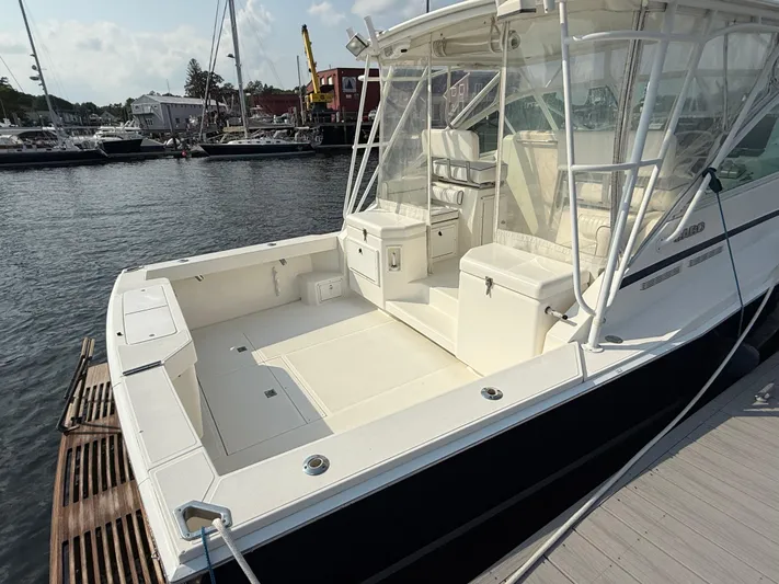 Club Car Yacht Photos Pics 1999 Cabo 31 Express boat docked, featuring spacious deck and seating area.