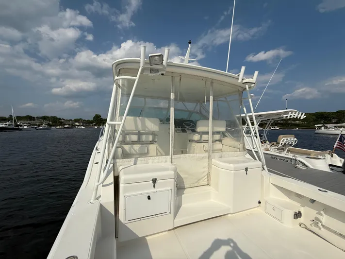 Club Car Yacht Photos Pics 1999 Cabo 31 Express boat docked, featuring a spacious deck and enclosed helm area.