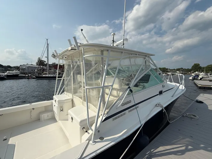 Club Car Yacht Photos Pics 1999 Cabo 31 Express boat docked at marina under partly cloudy sky.