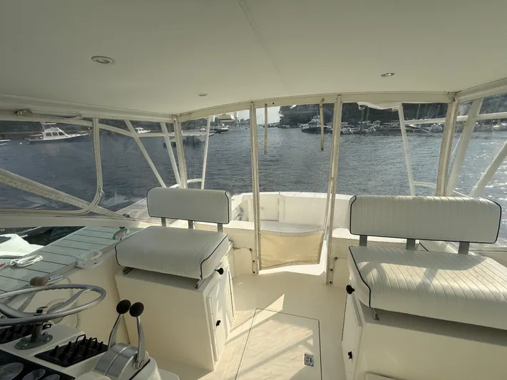 Club Car Yacht Photos Pics Interior view of 1999 Cabo 31 Express boat with helm and seating, overlooking marina.