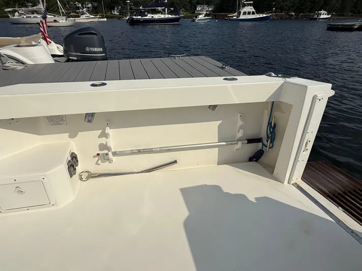 Club Car Yacht Photos Pics 1999 Cabo 31 Express boat deck with fishing rod holder, docked in a marina.