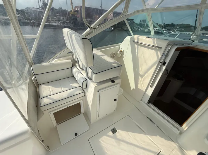 Club Car Yacht Photos Pics 1999 Cabo 31 Express boat interior with white seating and open storage compartment.