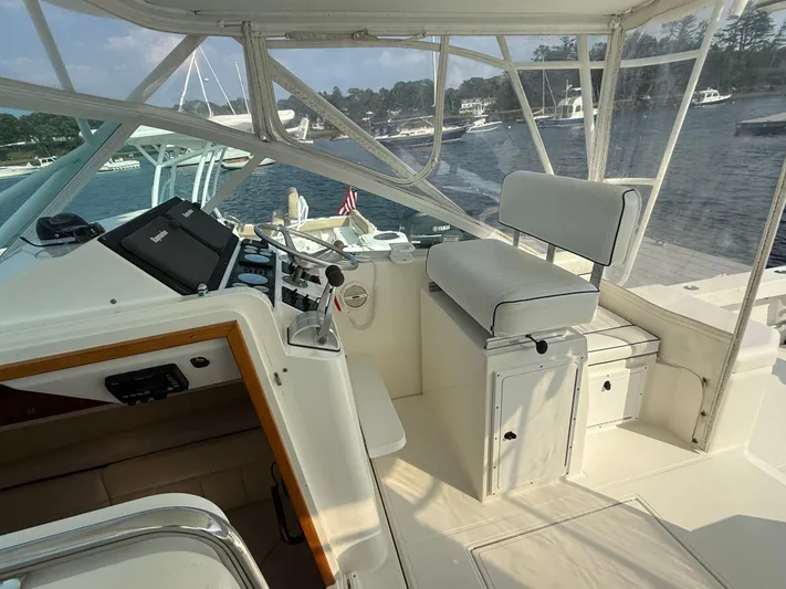 Club Car Yacht Photos Pics 1999 Cabo 31 Express boat interior with helm, seating, and marina view.