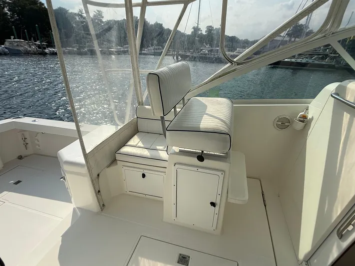 Club Car Yacht Photos Pics 1999 Cabo 31 Express boat interior with cushioned seating and waterfront view.