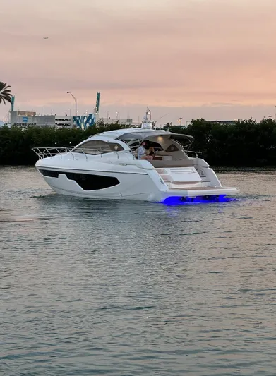  Yacht Photos Pics 2024 Sessa Marine C44 Cruiser on water at sunset with blue underwater lights.