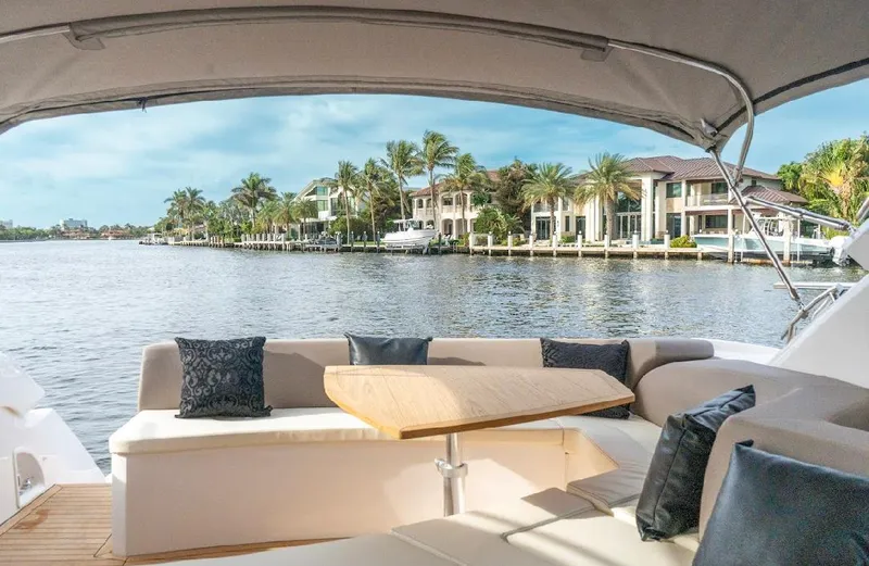  Yacht Photos Pics 2024 Sessa Marine C44 Cruiser interior with waterfront view, featuring elegant seating and table.