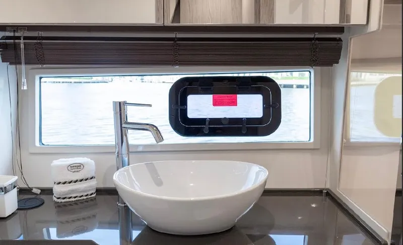  Yacht Photos Pics Modern bathroom interior of 2024 Sessa Marine C44 Cruiser with sleek sink and window view.