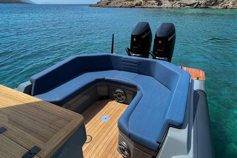 Rock Marine Rm 36 U | 36 S Yacht Photos Pics 2026 Rock Marine RM 36 boat with blue seating, dual engines, and wooden deck on clear water.