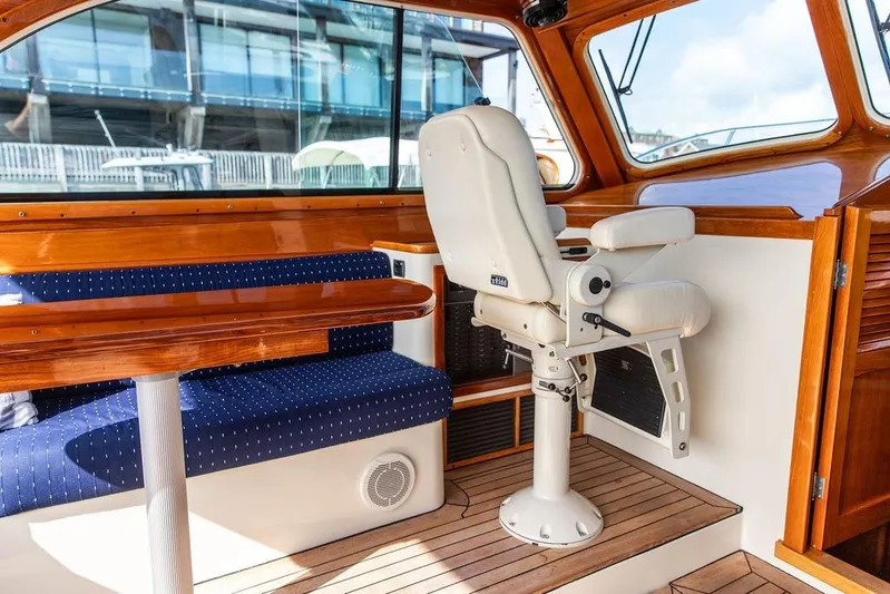 Swift Yacht Photos Pics Interior of 2005 Hinckley Talaria 40 yacht with wooden finishes and cushioned seating.