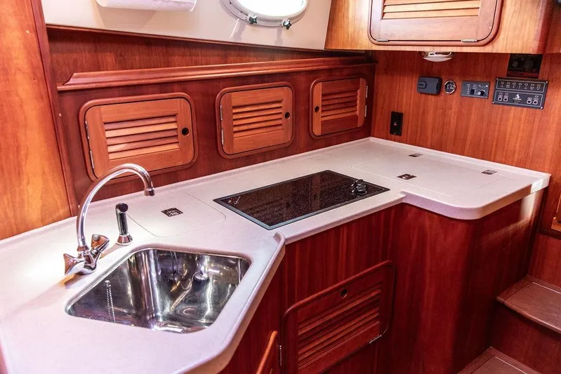 Swift Yacht Photos Pics Luxurious 2005 Hinckley Talaria 40 yacht kitchen with wooden cabinetry and modern sink.