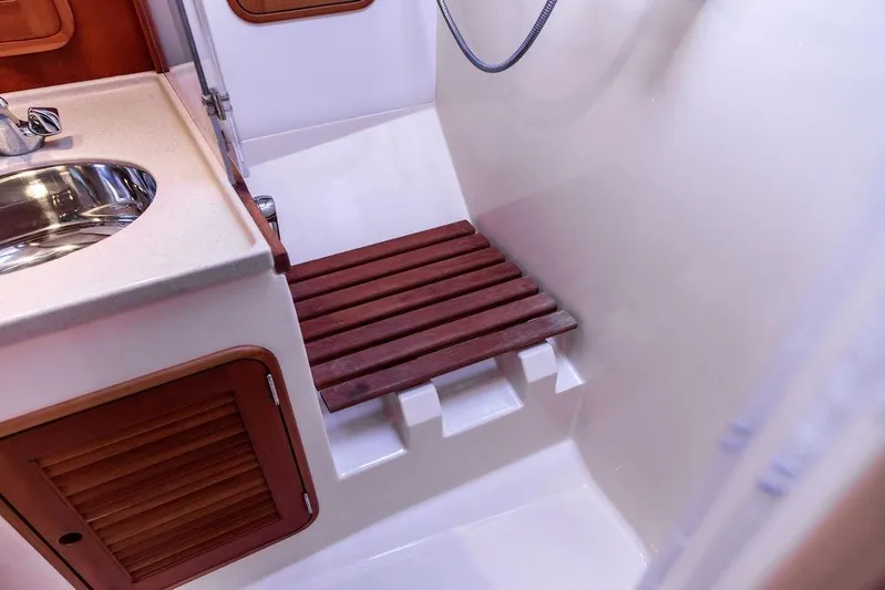 Swift Yacht Photos Pics Hinckley Talaria 40 (2005) yacht bathroom with wooden shower seat and stainless steel sink.