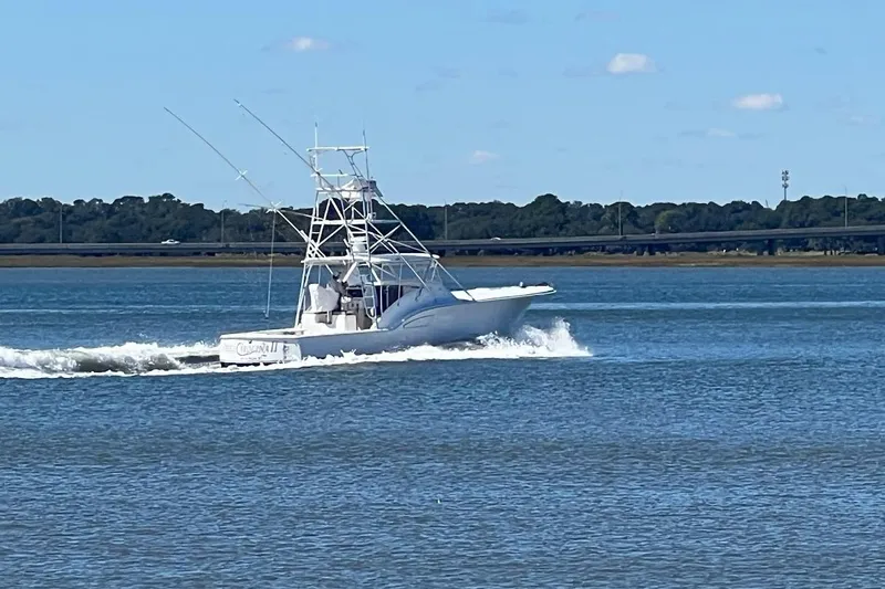 Reel Carolina II Yacht Photos Pics 2002 Out Island 38 Express Fisherman cruising on a calm blue waterway.