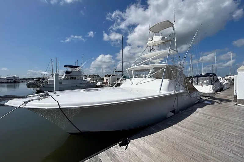 Reel Carolina II Yacht Photos Pics 2002 Out Island 38 Express Fisherman docked at marina under blue sky.