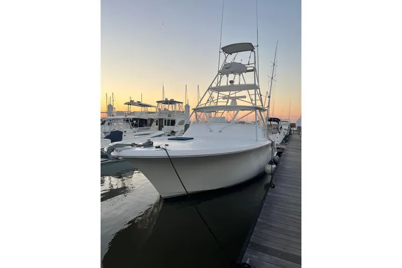 Reel Carolina II Yacht Photos Pics 2002 Out Island 38 Express Fisherman docked at sunset, showcasing sleek design and fishing tower.
