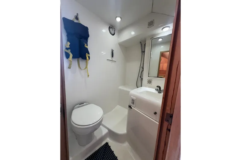 Reel Carolina II Yacht Photos Pics Compact bathroom in 2002 Out Island 38 Express Fisherman boat with toilet, sink, and life jacket.