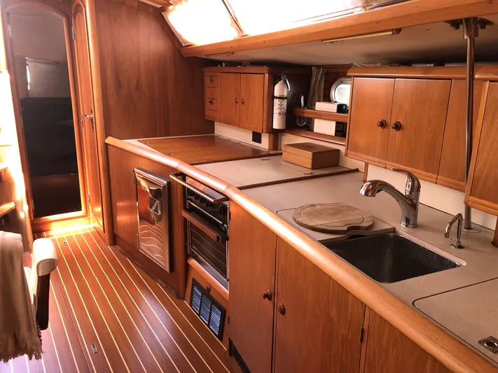 Ozymandias Yacht Photos Pics Interior of 2001 Jeanneau 45.2 yacht with wooden cabinetry and modern kitchen amenities.