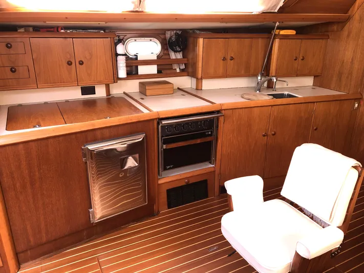 Ozymandias Yacht Photos Pics Interior of 2001 Jeanneau 45.2 yacht kitchen with wooden cabinets and appliances.