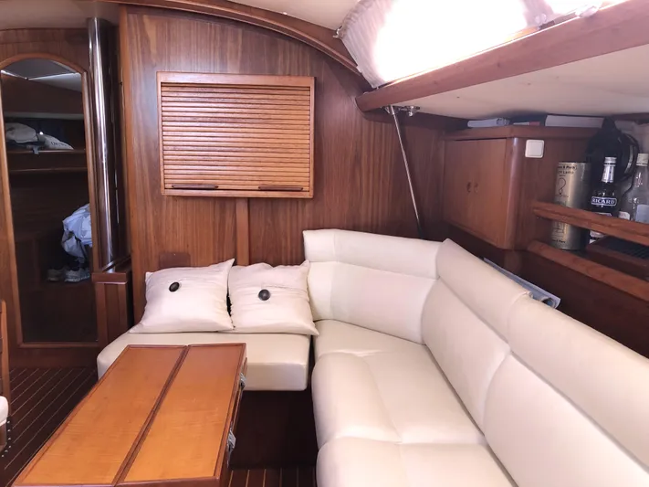 Ozymandias Yacht Photos Pics Interior of 2001 Jeanneau 45.2 yacht with white leather seating and wooden accents.