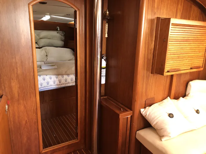 Ozymandias Yacht Photos Pics Interior of 2001 Jeanneau 45.2 yacht with wooden finish and cozy bedding.