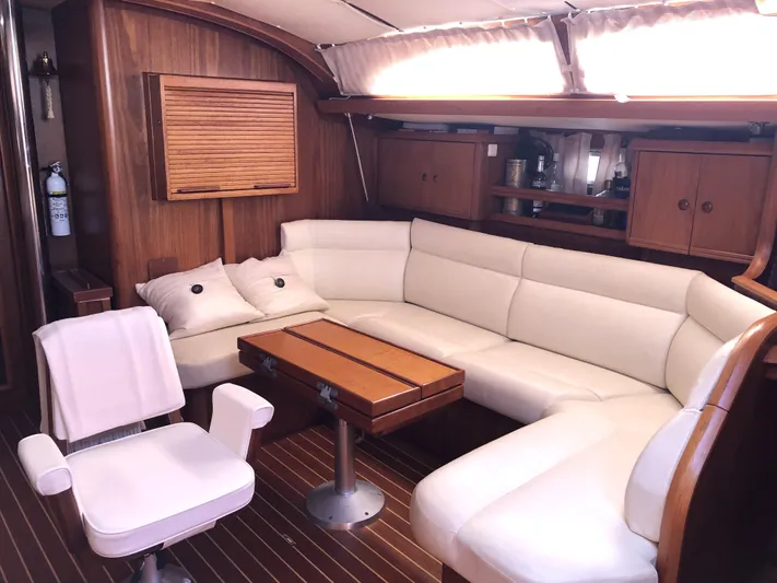 Ozymandias Yacht Photos Pics Luxurious interior of 2001 Jeanneau 45.2 yacht with white leather seating and wooden accents.