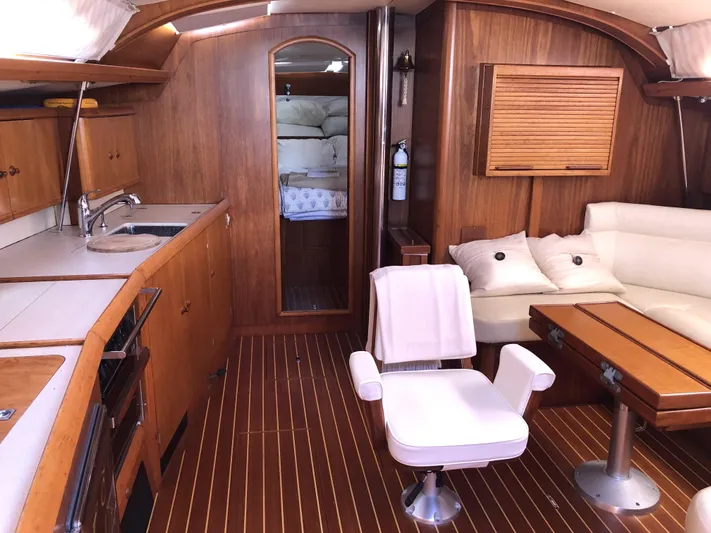 Ozymandias Yacht Photos Pics Interior of 2001 Jeanneau 45.2 yacht with wood finish and comfortable seating.