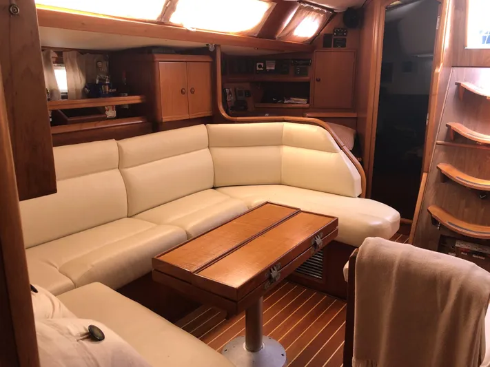 Ozymandias Yacht Photos Pics Luxurious interior of 2001 Jeanneau 45.2 yacht with cream leather seating and wooden accents.