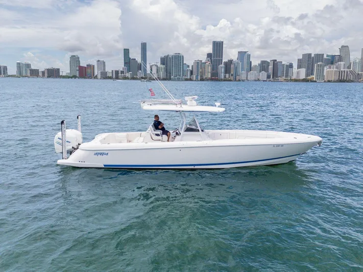  Yacht Photos Pics 2021 Intrepid 345 Nomad FE boat cruising near city skyline on a sunny day.