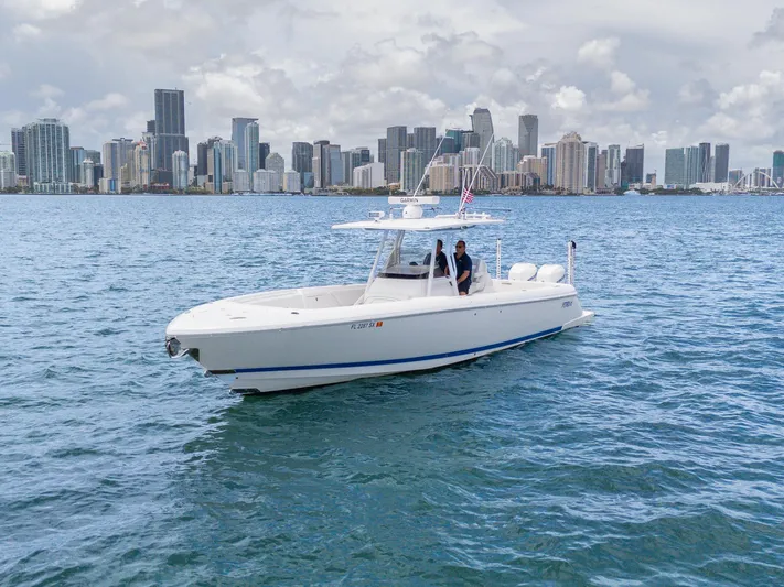  Yacht Photos Pics 2021 Intrepid 345 Nomad FE boat cruising near city skyline on a clear day.