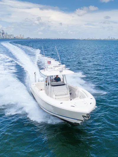  Yacht Photos Pics 2021 Intrepid 345 Nomad FE boat cruising on open water, city skyline in background.