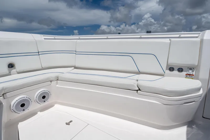  Yacht Photos Pics 2021 Intrepid 345 Nomad FE boat seating with white cushions and blue accents under cloudy sky.