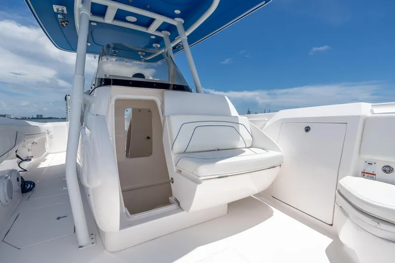  Yacht Photos Pics 2021 Intrepid 345 Nomad FE boat interior with seating and storage under a blue sky.