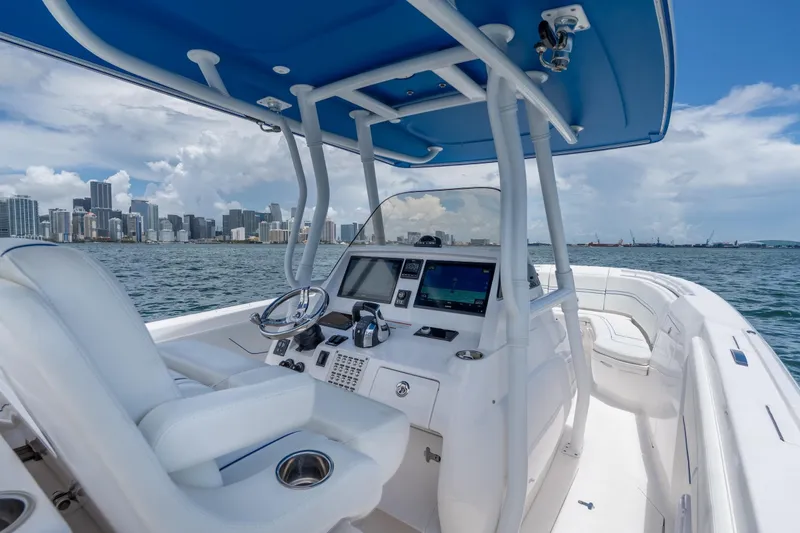  Yacht Photos Pics 2021 Intrepid 345 Nomad FE boat with city skyline in background, featuring modern helm controls.