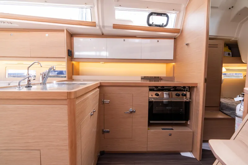 Lunar Sea Yacht Photos Pics Modern kitchen interior of 2023 Dufour 390 yacht with wood finish and built-in appliances.