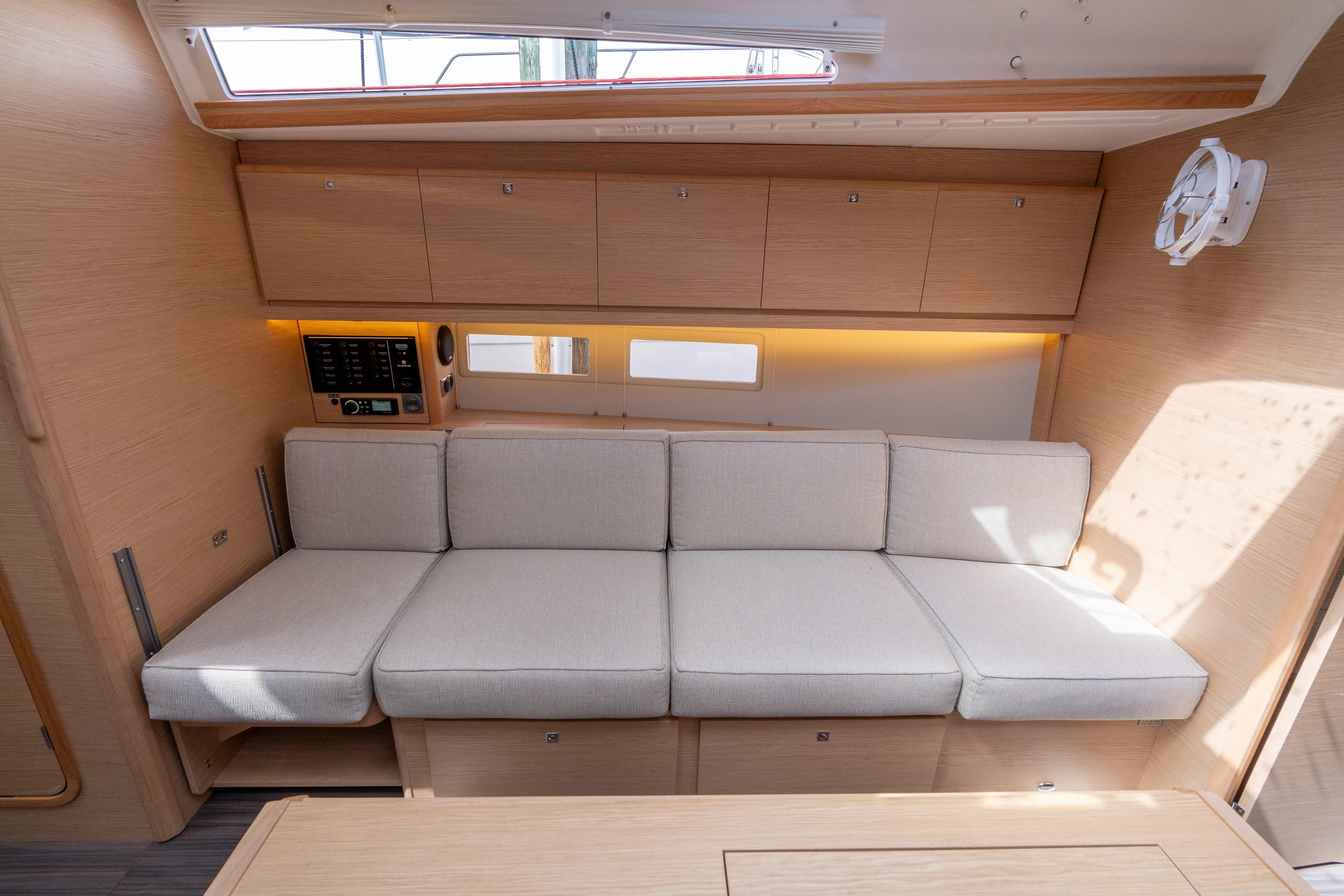 Lunar Sea Yacht Photos Pics Modern interior of 2023 Dufour 390 yacht with beige seating and wooden cabinetry.
