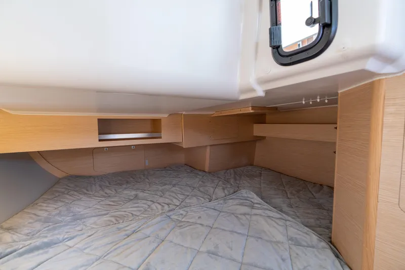 Lunar Sea Yacht Photos Pics 2023 Dufour 390 yacht cabin interior with wooden finish and cozy bedding.