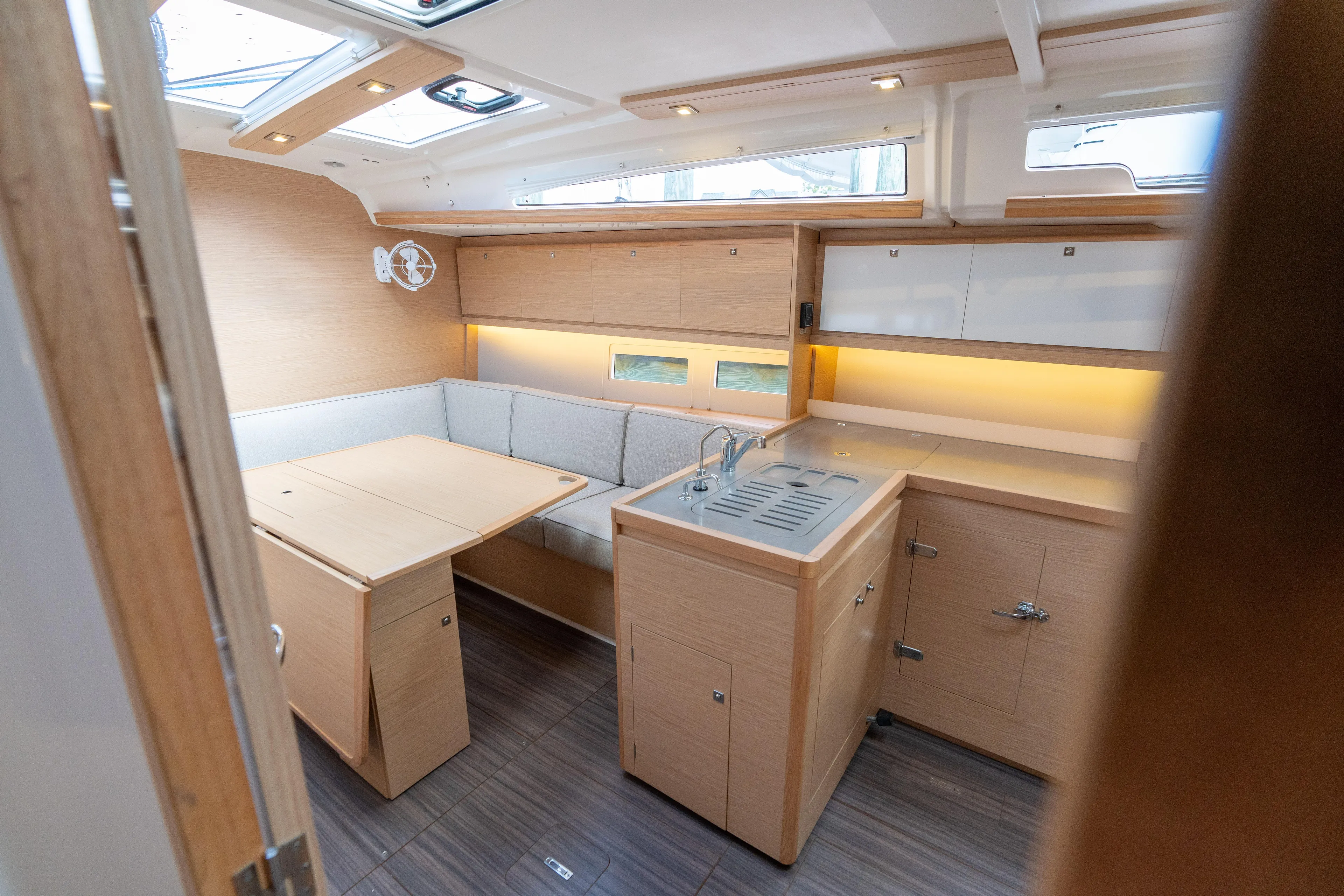 Lunar Sea Yacht Photos Pics Interior of 2023 Dufour 390 yacht, featuring modern kitchen and dining area with wood finish.