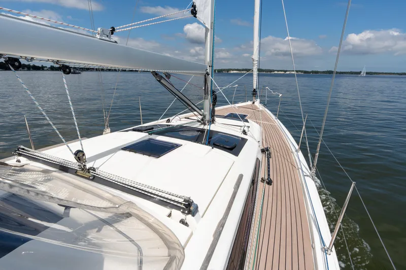 Lunar Sea Yacht Photos Pics 2023 Dufour 390 sailboat on calm waters under a clear blue sky.