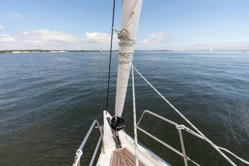 Lunar Sea Yacht Photos Pics Bow view of 2023 Dufour 390 sailboat on calm waters under a clear sky.