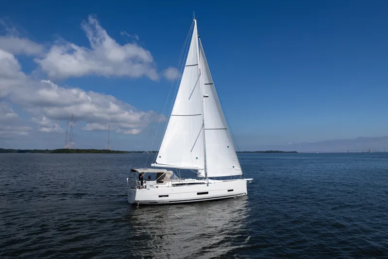 Lunar Sea Yacht Photos Pics 2023 Dufour 390 sailboat cruising on open water under a clear blue sky.