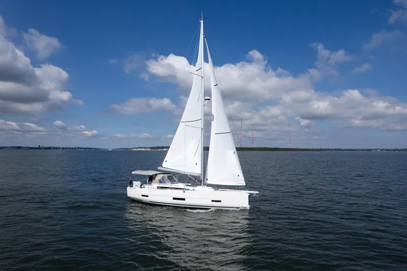 Lunar Sea Yacht Photos Pics 2023 Dufour 390 sailboat cruising on a calm sea under a clear blue sky.
