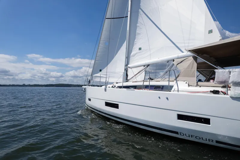 Lunar Sea Yacht Photos Pics 2023 Dufour 390 sailboat gliding on open water under clear blue skies.
